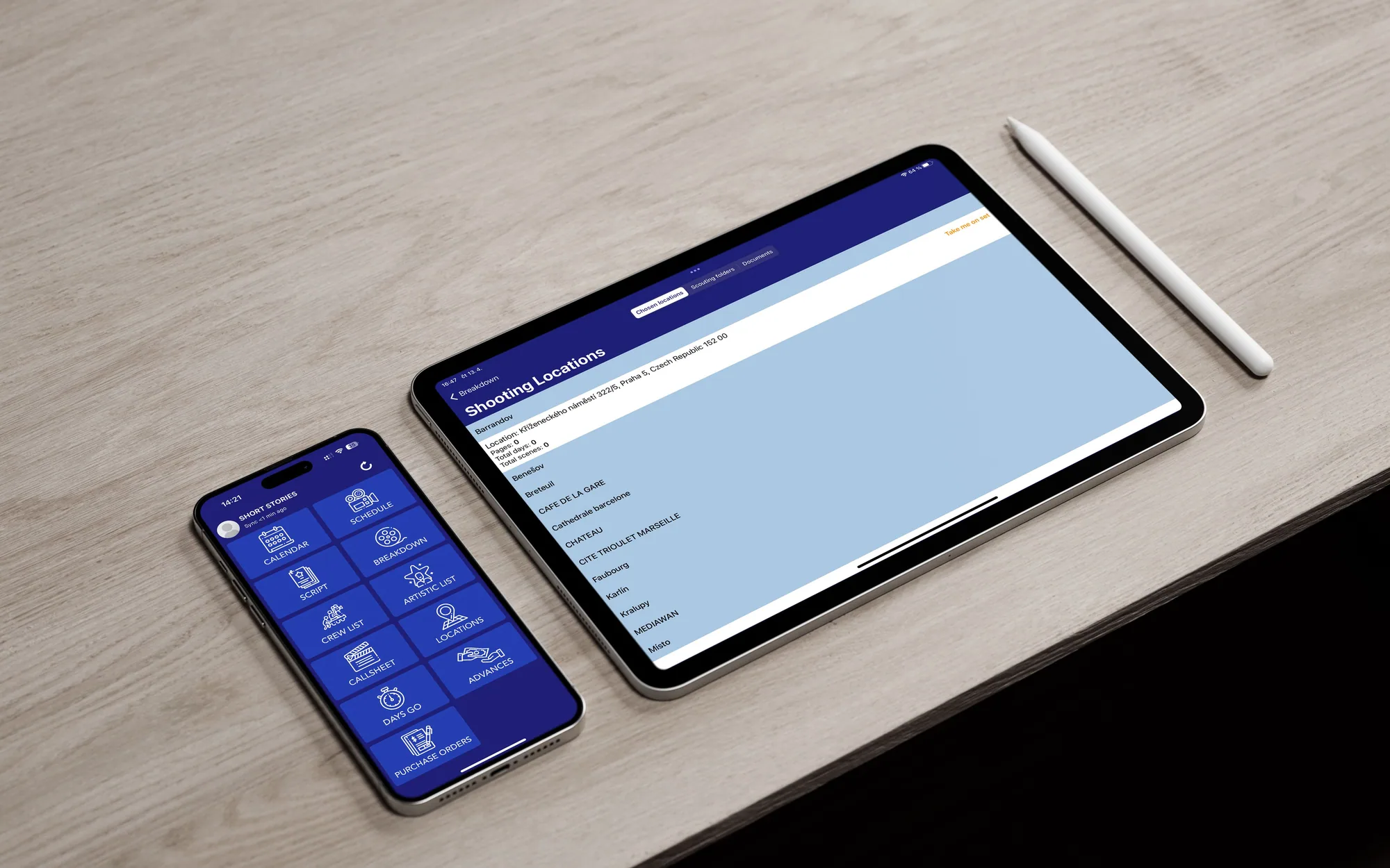 A phone and a tablet side by side on a pale wooden desk with an Apple Pencil: the phone showing the app's tool menu, the tablet a list of shooting locations.
