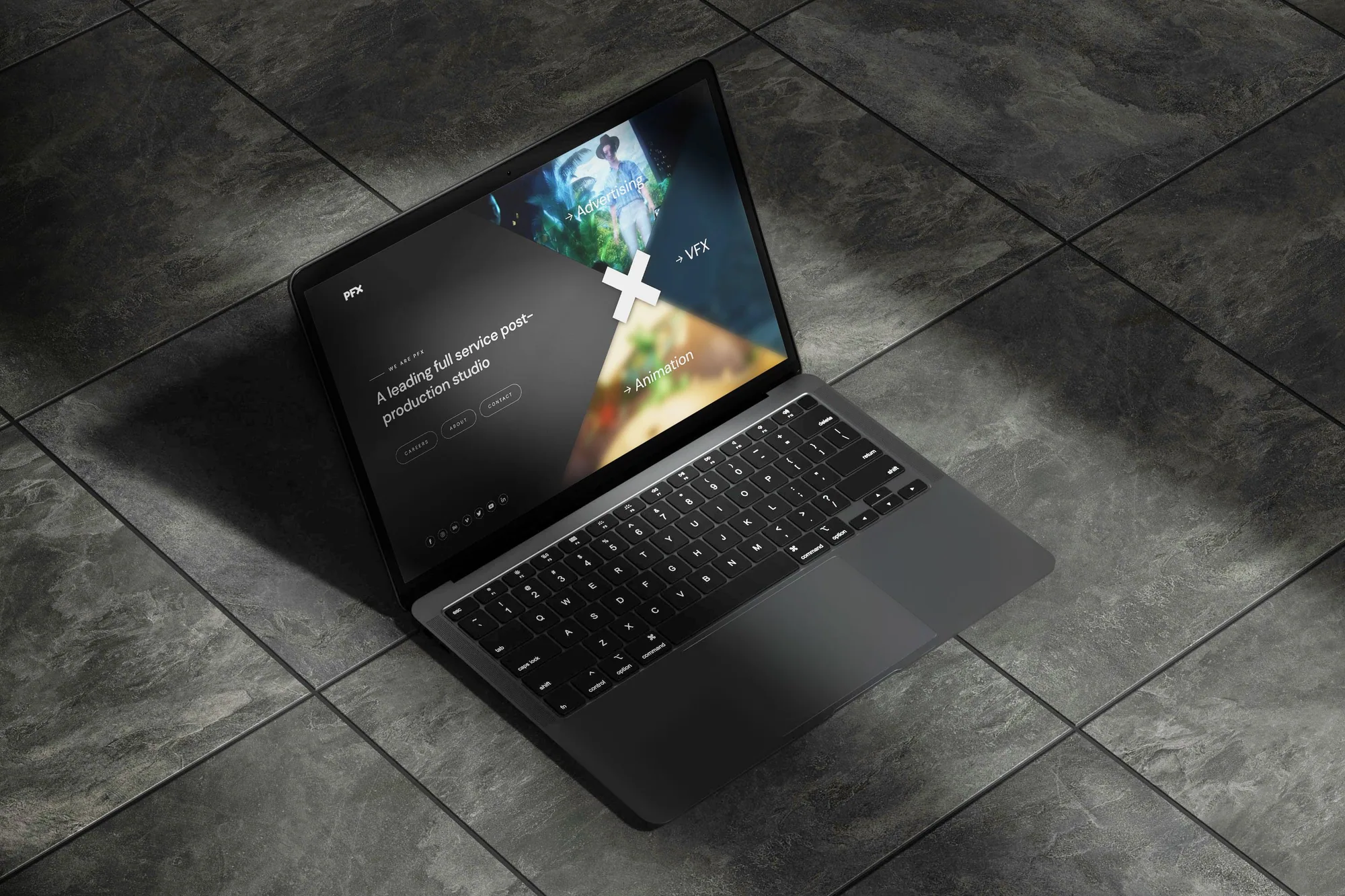 A laptop on a dark tiled floor showing the PFX homepage: “A leading full service post-production studio” beside three angled panels for Advertising, VFX and Animation.